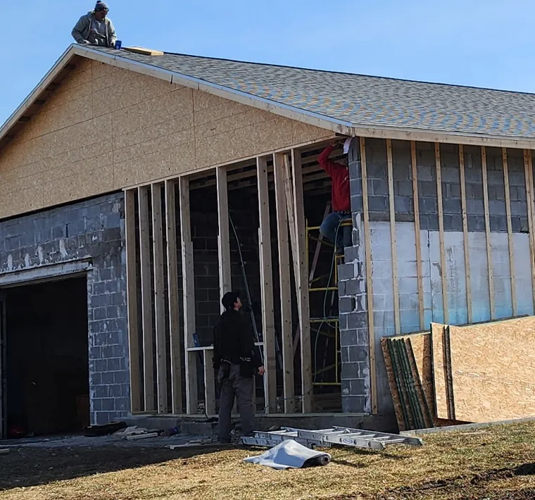 Exterior building under construction with new framing and roofing by Go2 Exteriors