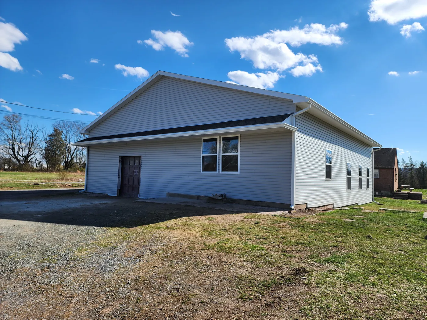 Completed building with new vinyl siding, seamless gutters, and windows by Go2 Exteriors