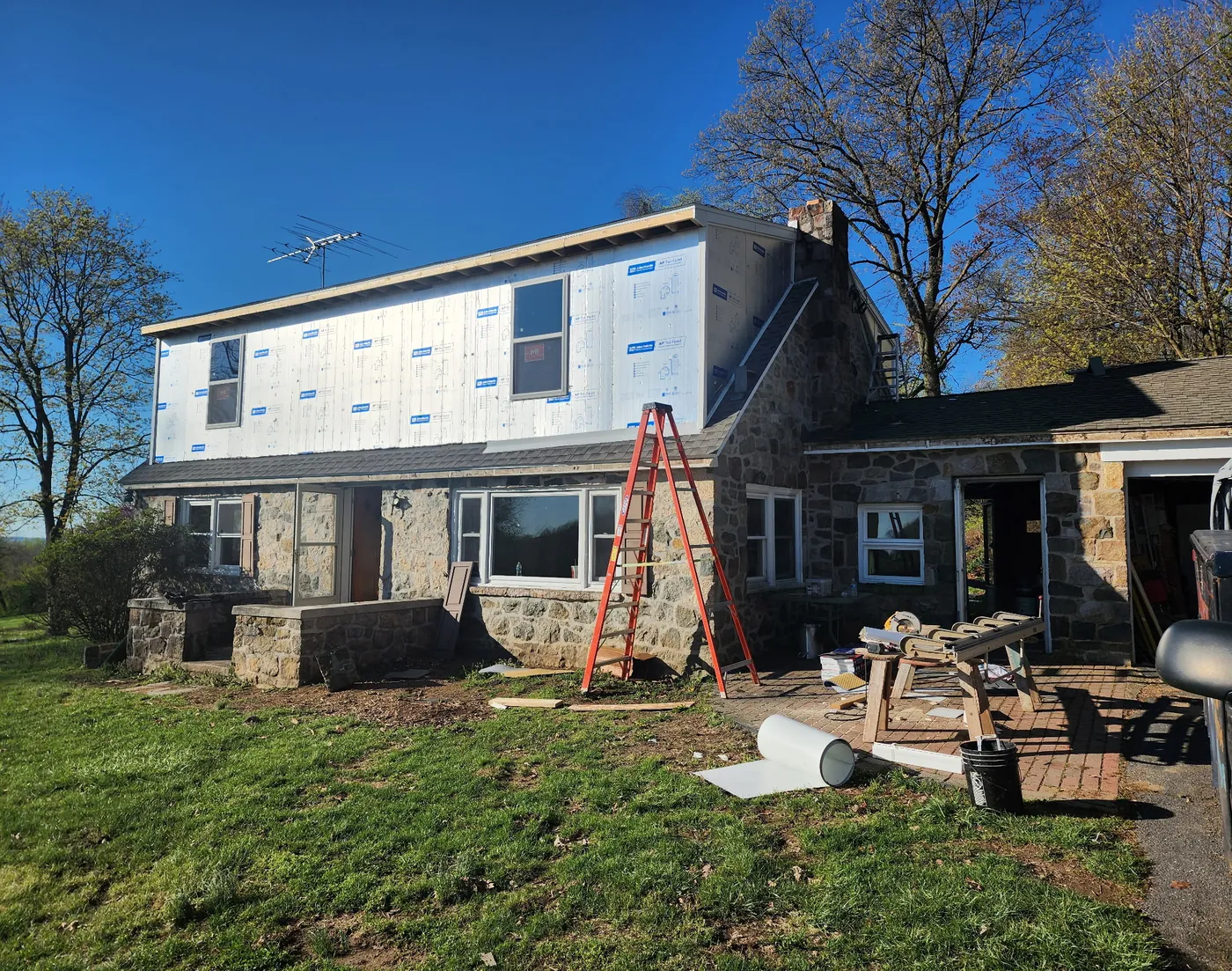 Stone home with newly installed replacement windows by Go2 Exteriors